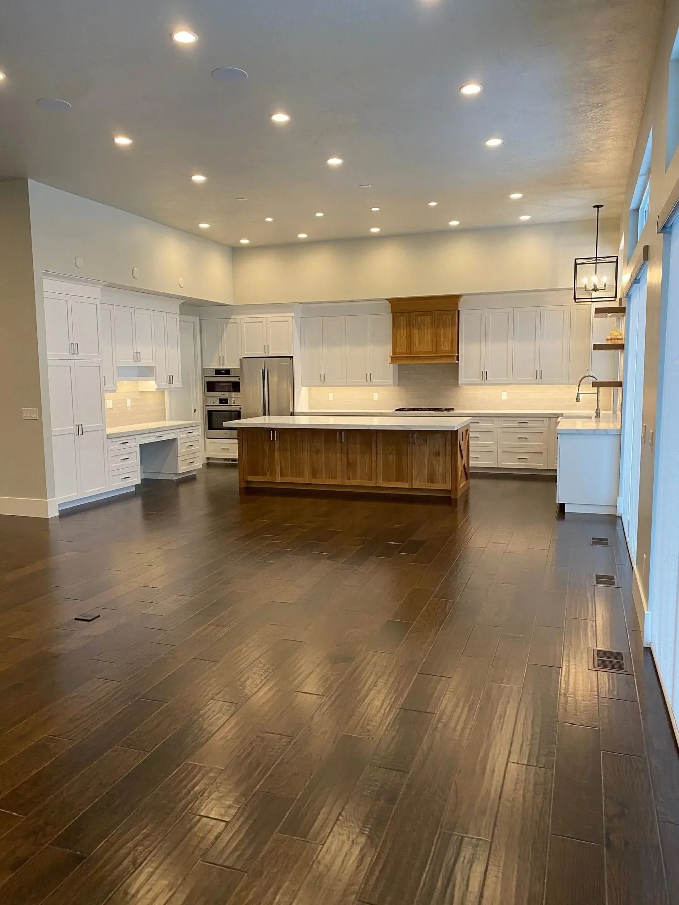 Open white kitchen with walnut island and dark hardwood floor