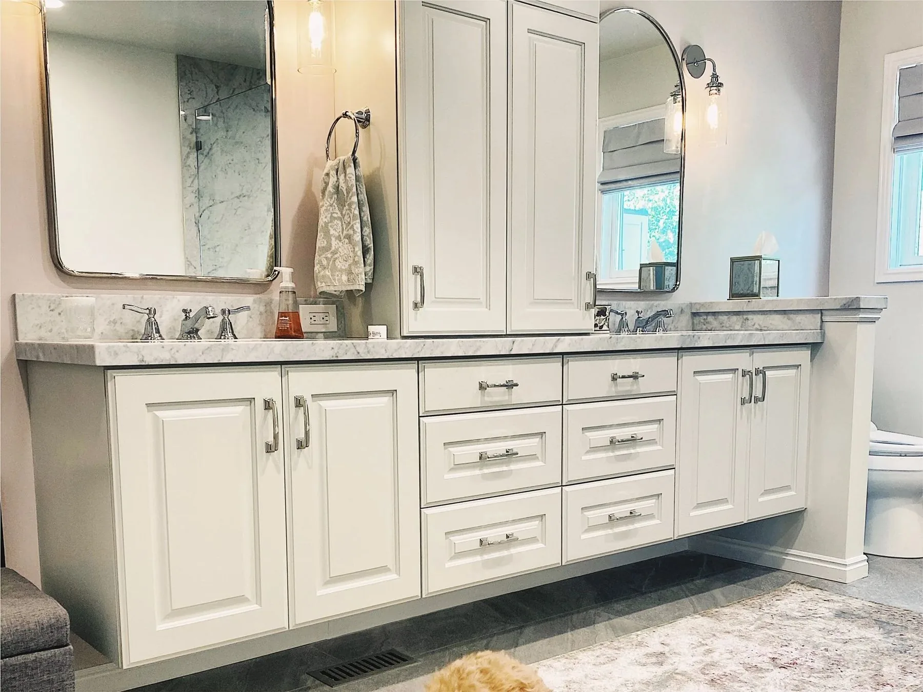 White double vanity with marble top and arched mirror