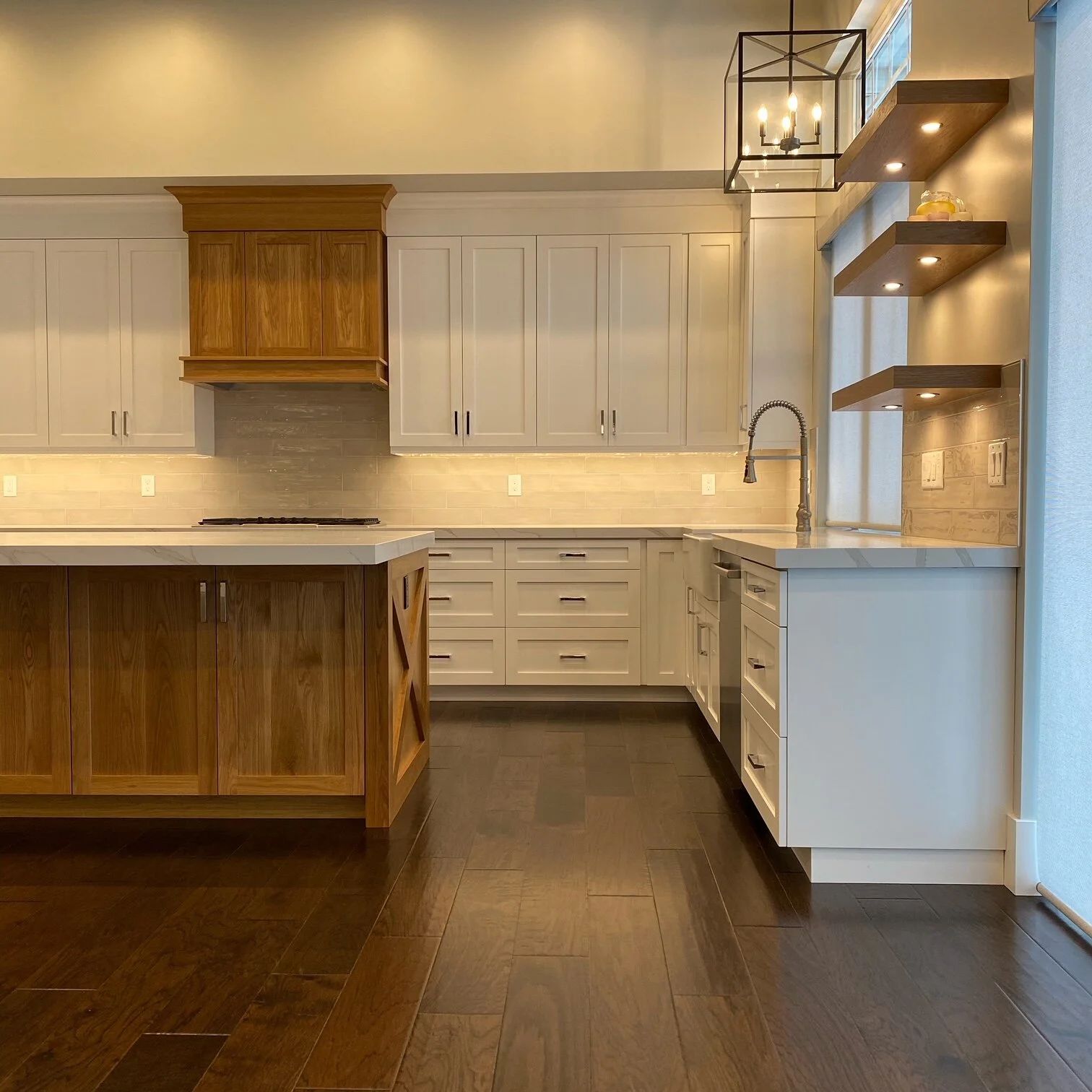 White kitchen with wood range hood and dark island
