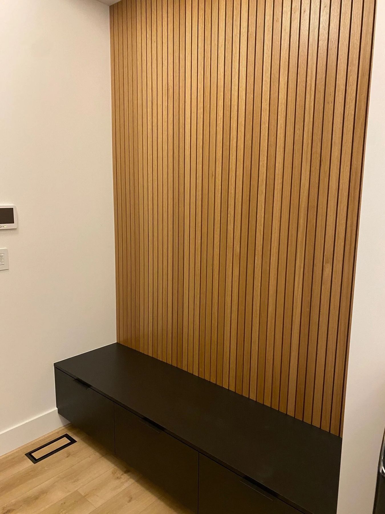 Custom wood slat wall with floating black bench
